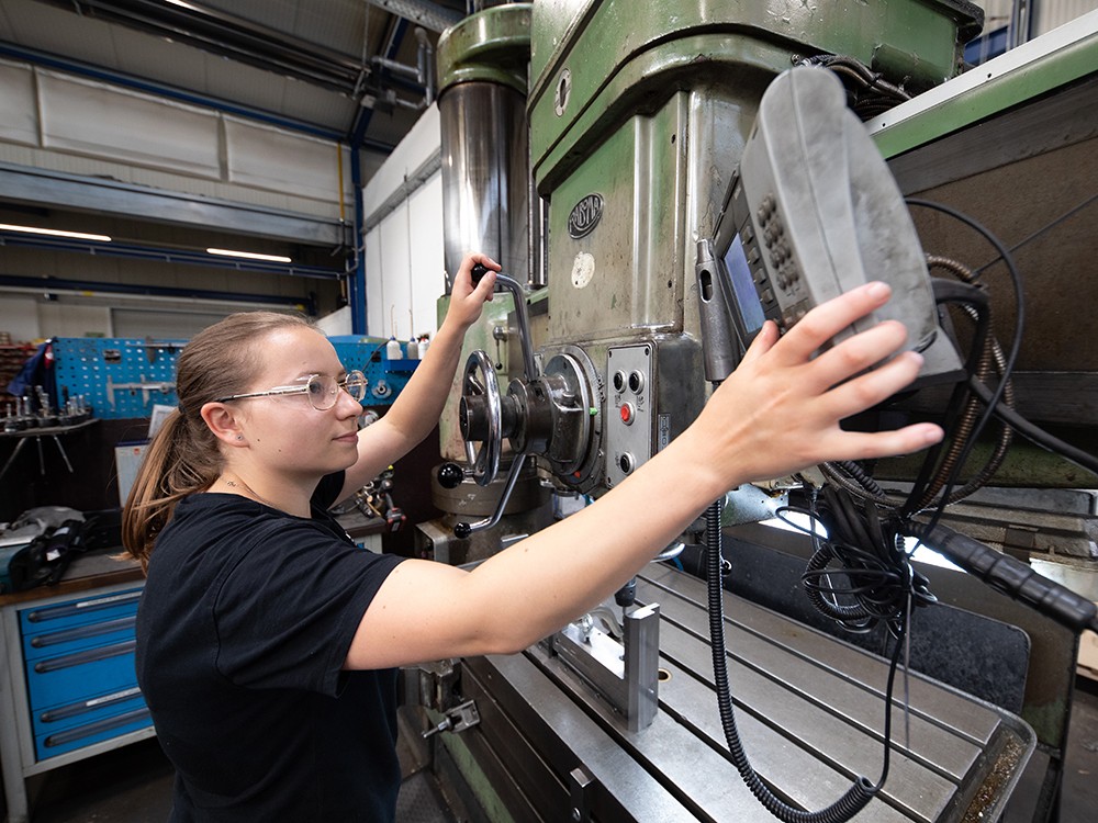 Mitarbeiterin stellt Bohrmaschine ein